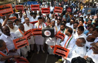 ಪೋಸ್ಟರ್ ಅಂಟಿಸಿ, ಸೂಟ್’ಕೇಸ್’ನಲ್ಲಿ ನಕಲಿ ನೋಟು ಪ್ರದರ್ಶಿಸಿ ಸರ್ಕಾರದ ವಿರುದ್ಧ ಕಾಂಗ್ರೆಸ್ ಪ್ರತಿಭಟನೆ